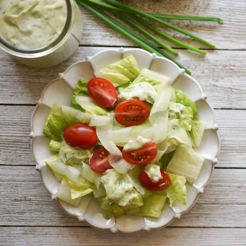 Classic Presentation of Green Goddess Salad Dressing on Butter Lettuce with Cucmber and Halved Cherry Tomatoes