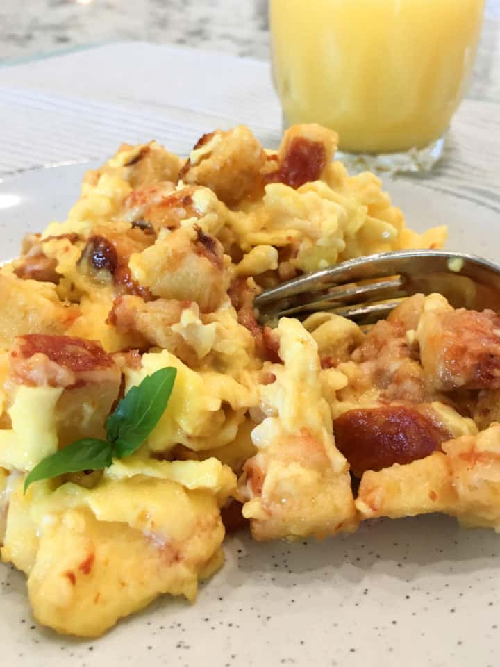 Pizza eggs plated with a sprig of basil and served with orange juice.