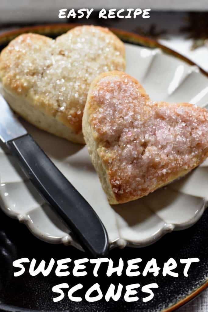 Two heart shaped scones plated on a ruffled beige dish. Pinterest Pin 17.