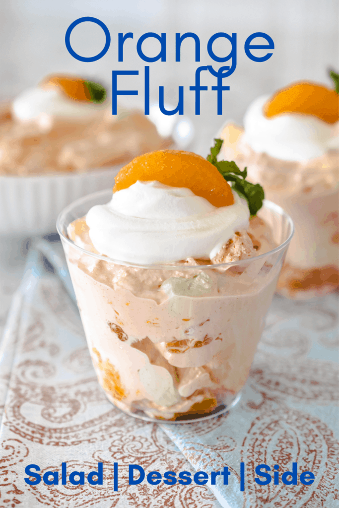 Portrait image of a close up view of orange fluff in small cups and a bowl. Each serving is garnished with whipped topping, a mandarin orange, and a sprig of mint. Pinterest PIN #5