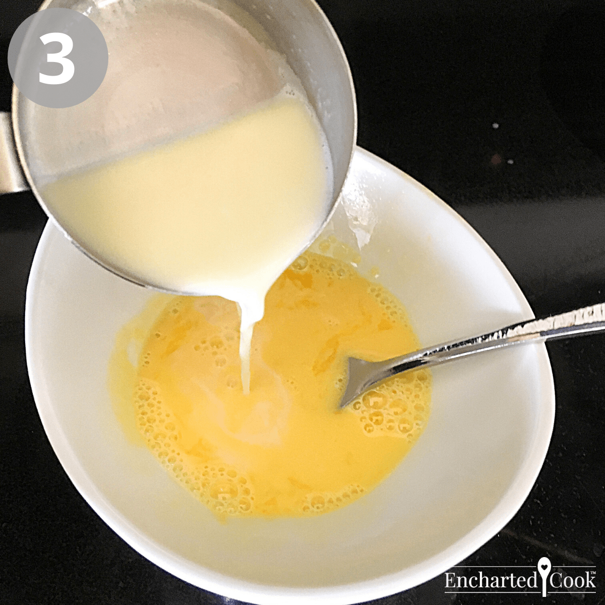 A small amount of hot milk and cream is being added to the egg yolks.