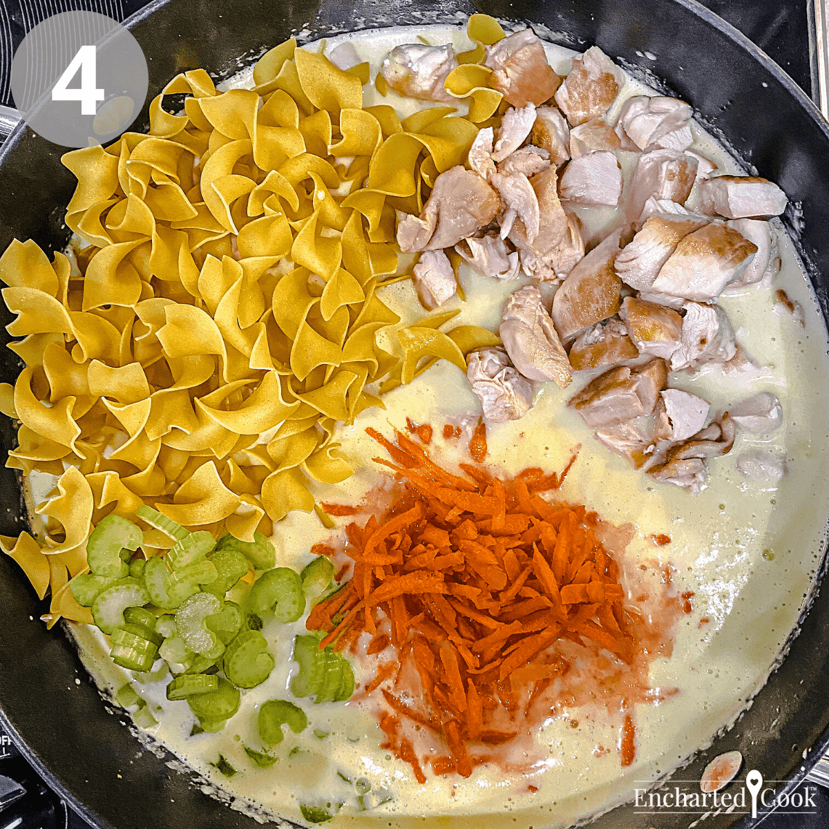 Adding the cut chicken, shredded carrots, celery, and egg noodles to the soup base.