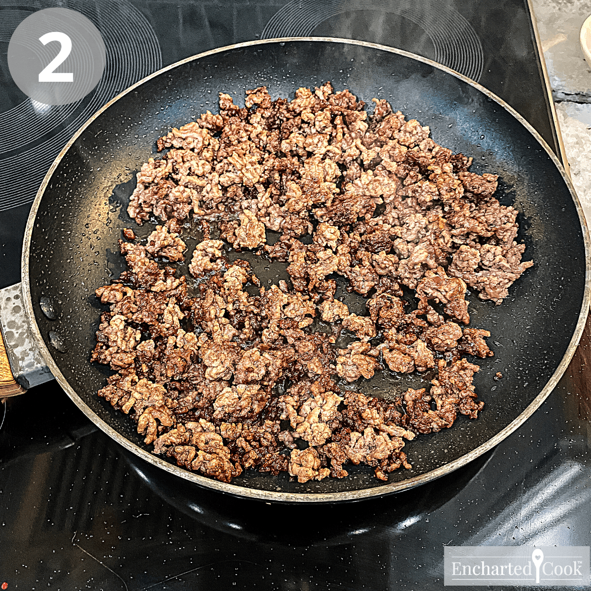 Ground beef is well browned in a skillet on the stove.