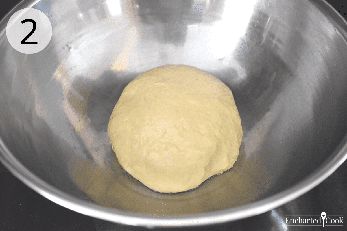 The dough is gathered into a ball and placed in an oiled stainless steel bowl.