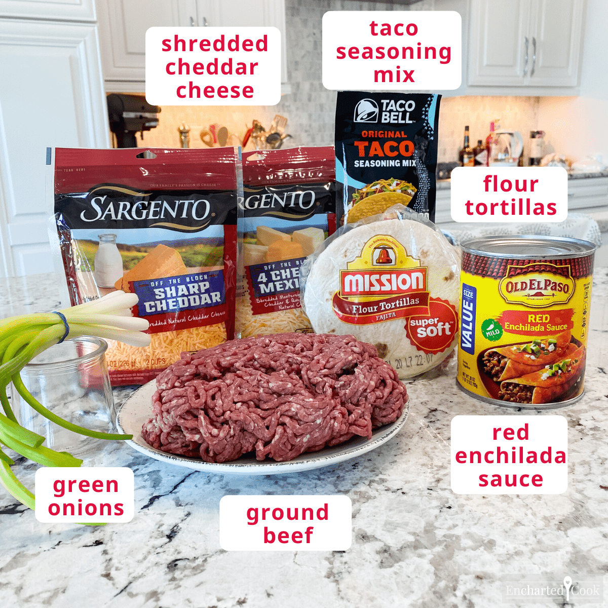 Ingredients with text overlay labels. Clockwise from top right: taco seasoning mix, flour tortillas, red enchilada sauce, ground beef, green onions, shredded cheddar cheese.