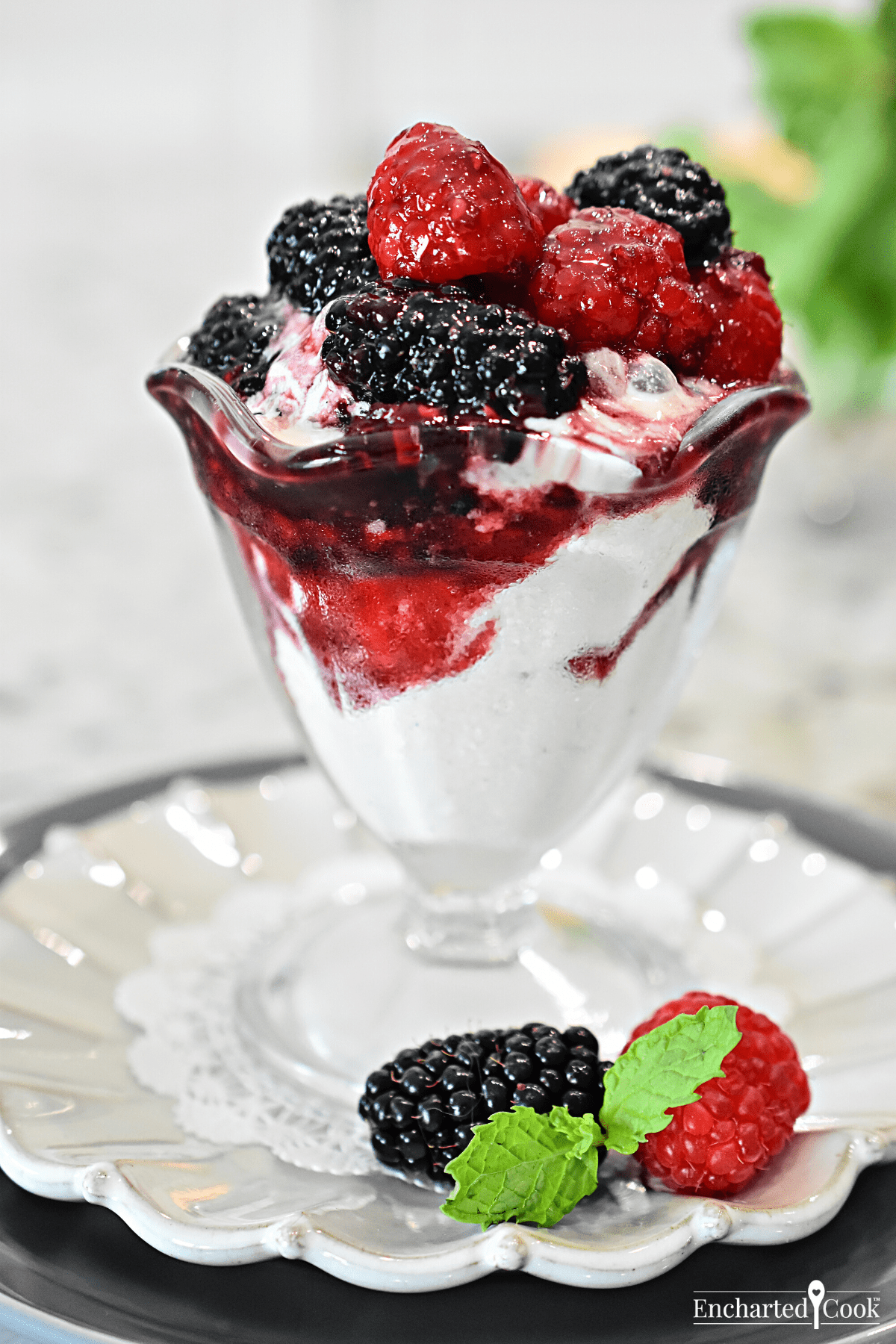 Berries and a deep red sauce over vanilla ice cream.