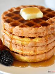 Four chaffles stacked with butter, syrup, and berries.
