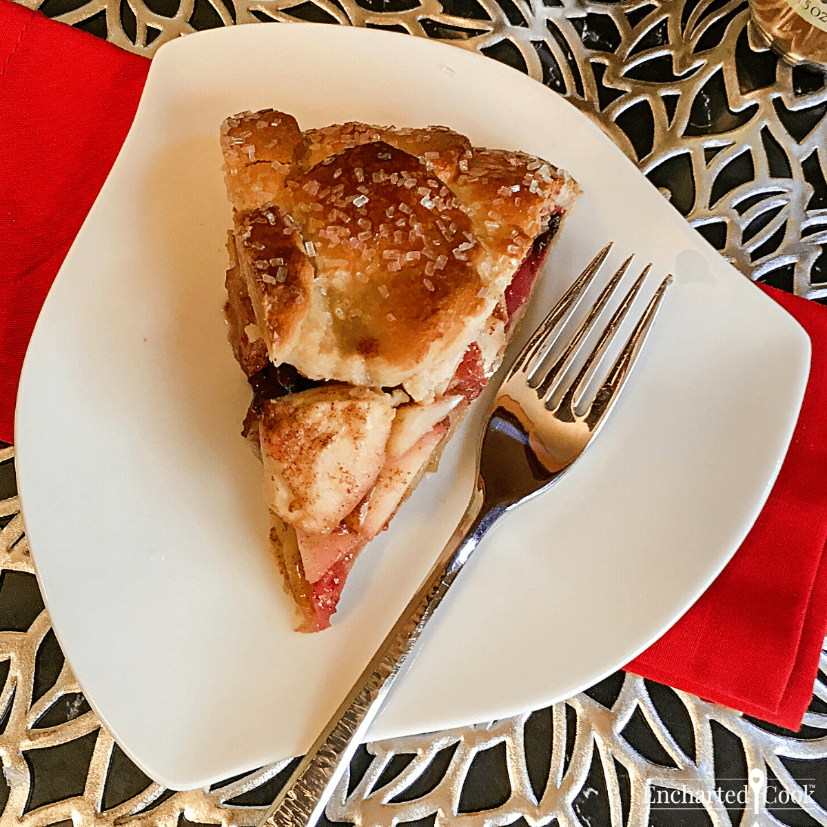 A slice of pie on a white plate with a fork and red napkin.