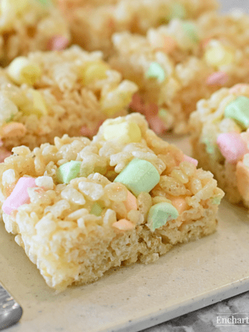 Treats with pastel mini marshmallows on a cutting board.