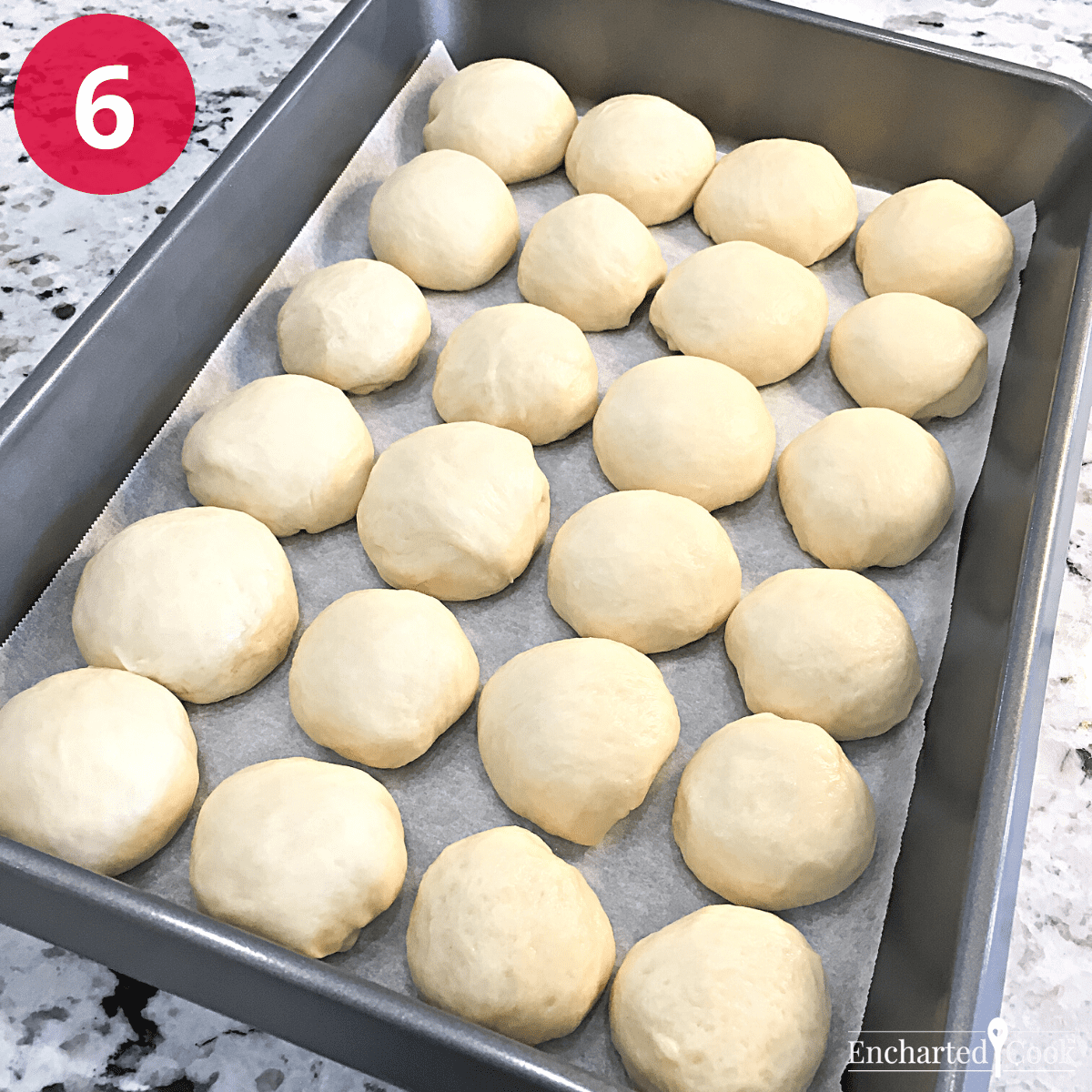 The dinner roll dough balls are placed in a baking pan.