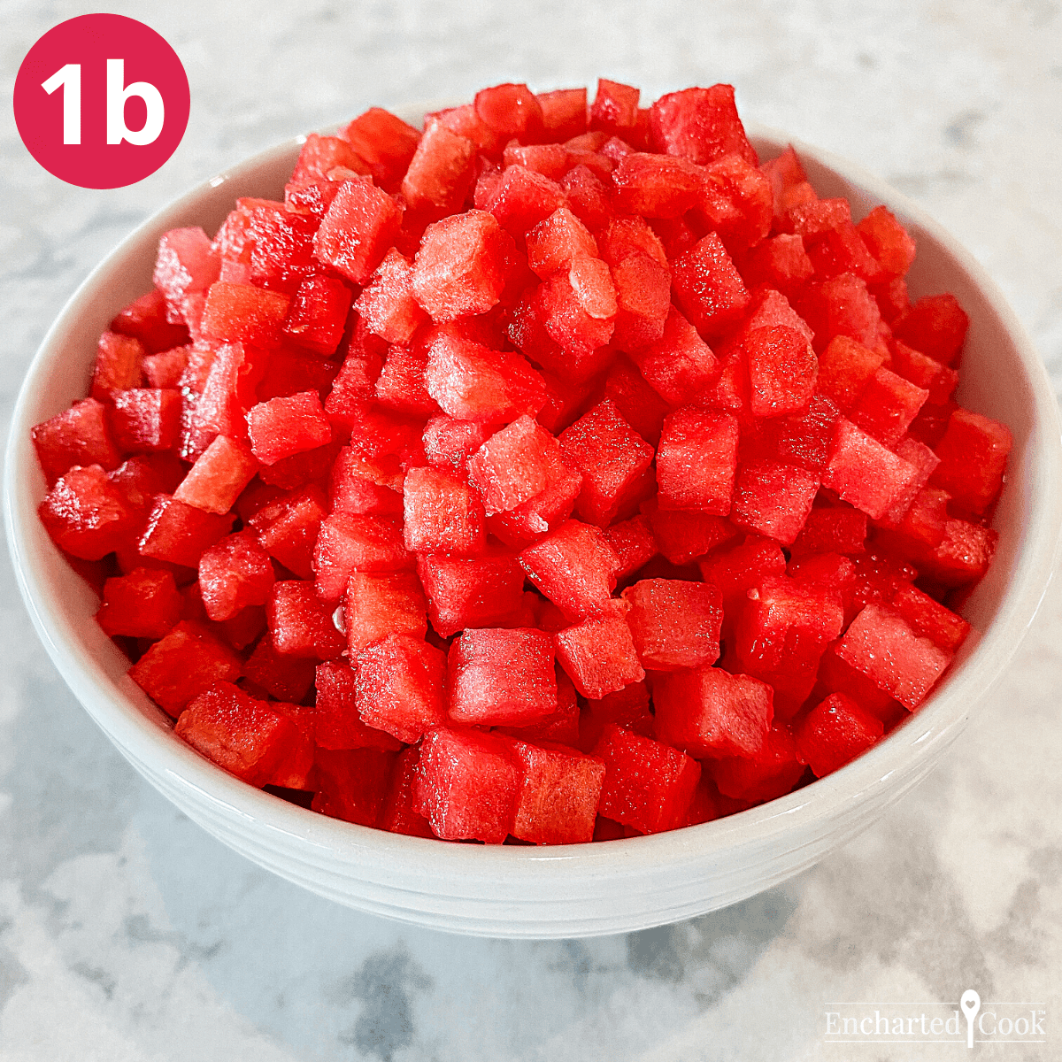 A white bowl filled with tiny cubes of water melon.