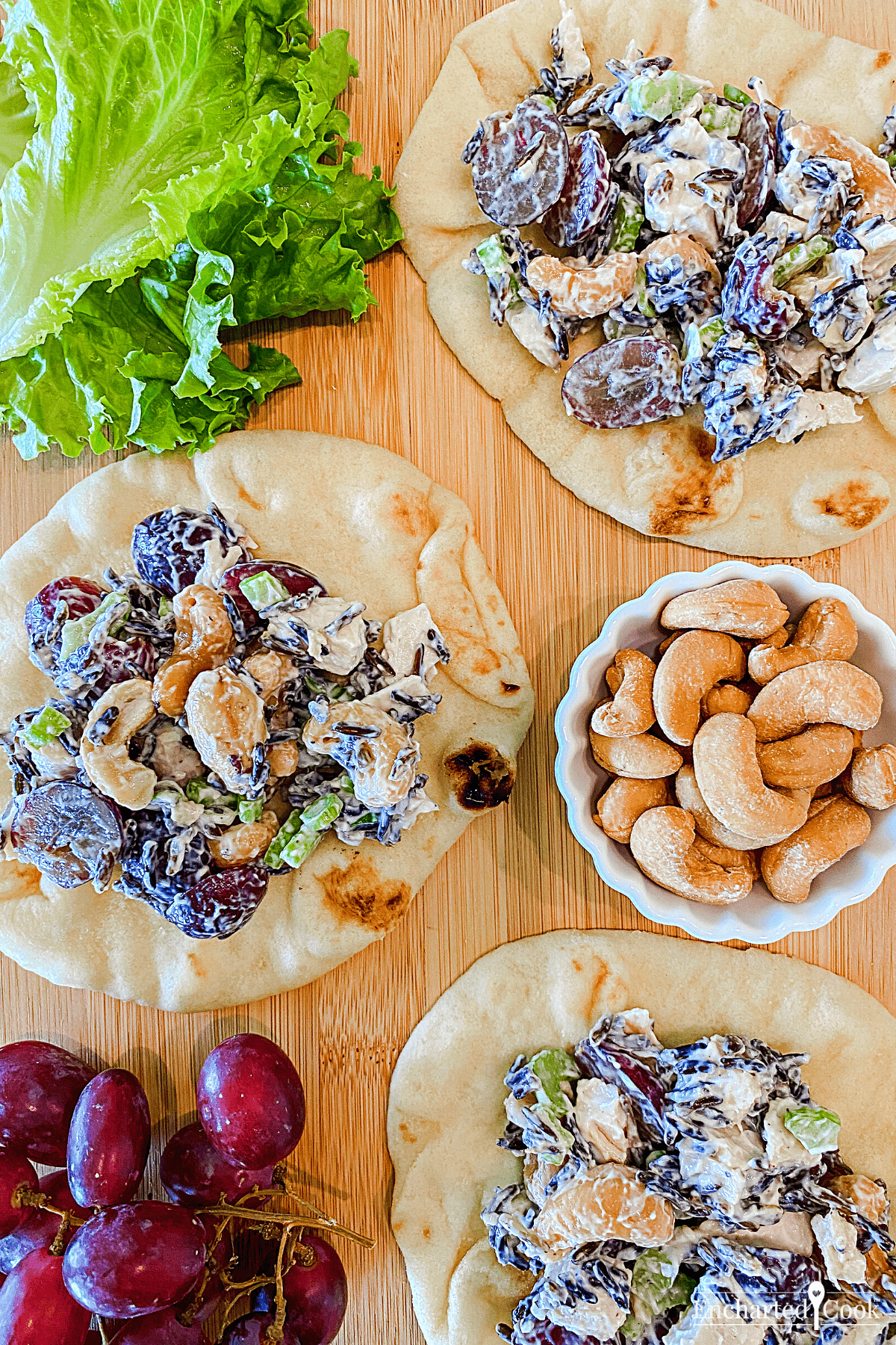 Lettuce, cashews, grapes, and chicken salad on naan bread.