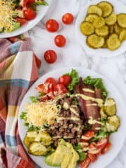 Ground beef and bacon cheeseburger salad on a white plate.