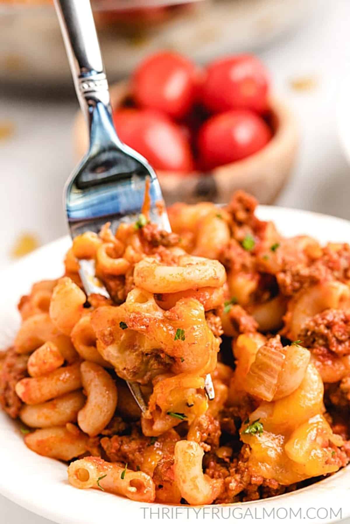 Macaroni and ground beef in a white dish with a fork.