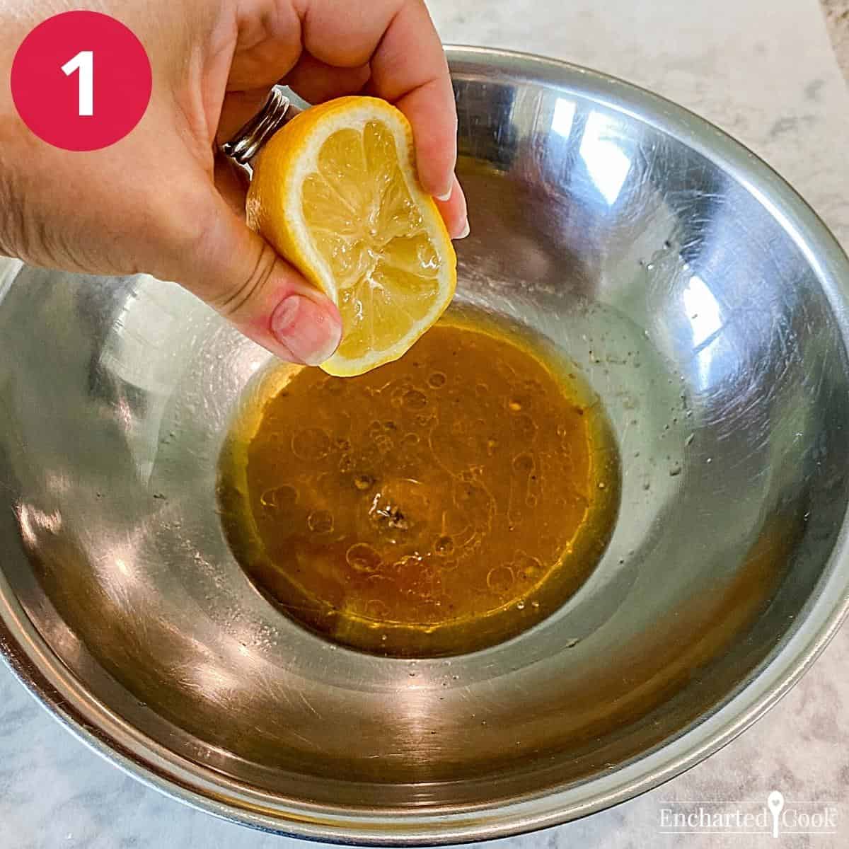 Squeezing fresh lemon juice by hand into Italian salad dressing.