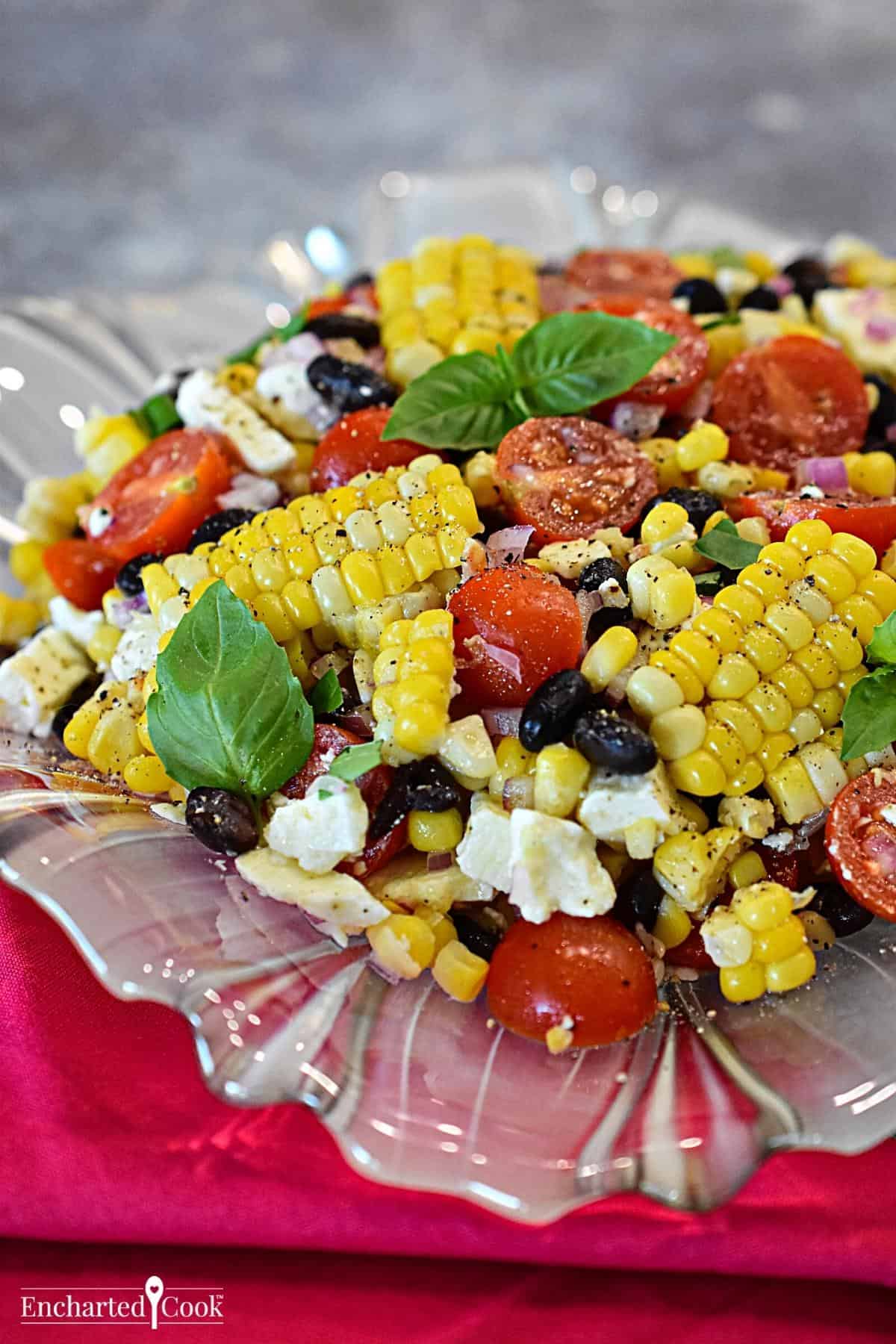 Corn salad on a glass plate with a red napkin.