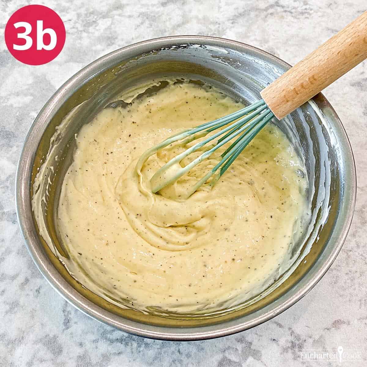 The salad dressing ingredients mixed together in a small bowl with a whisk.