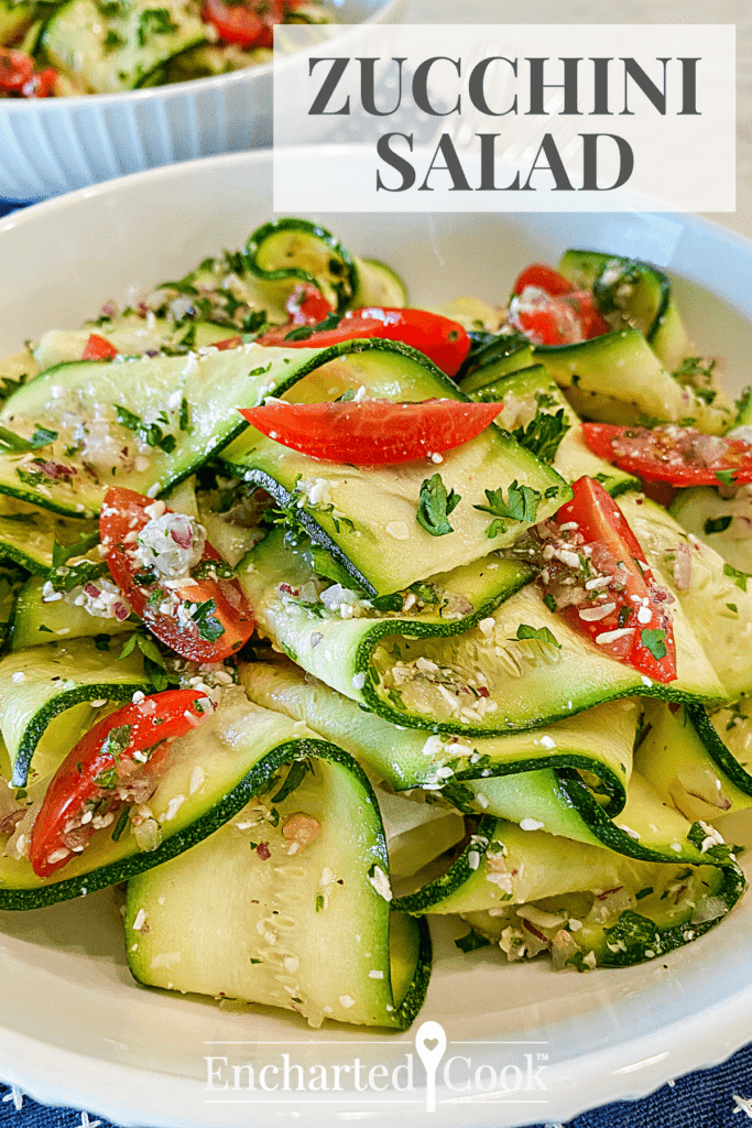 A white bowl filled with thin ribbons of zucchini and cherry tomatoes with text overlay.