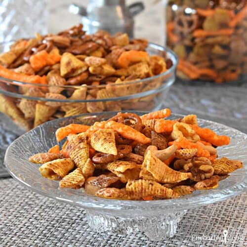 Plates and bowls of party snack mix ready for guests to eat.