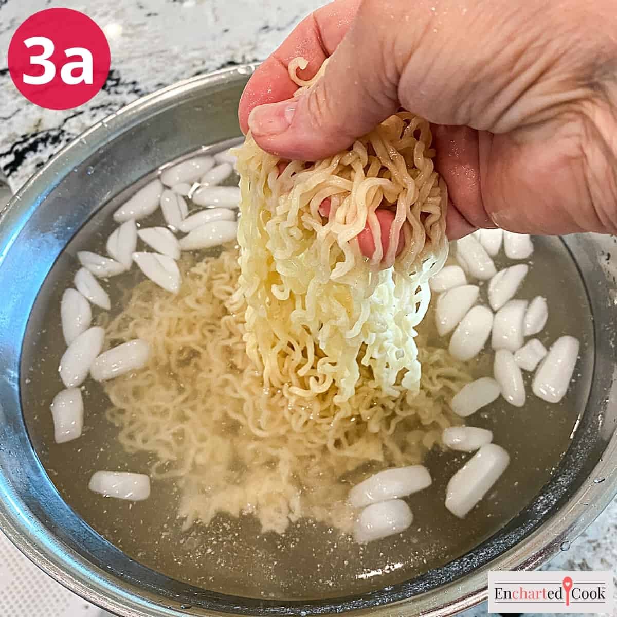 Process Photo 3a - Cooling and rinsing the cooked ramen noodles in a bowl of ice water.