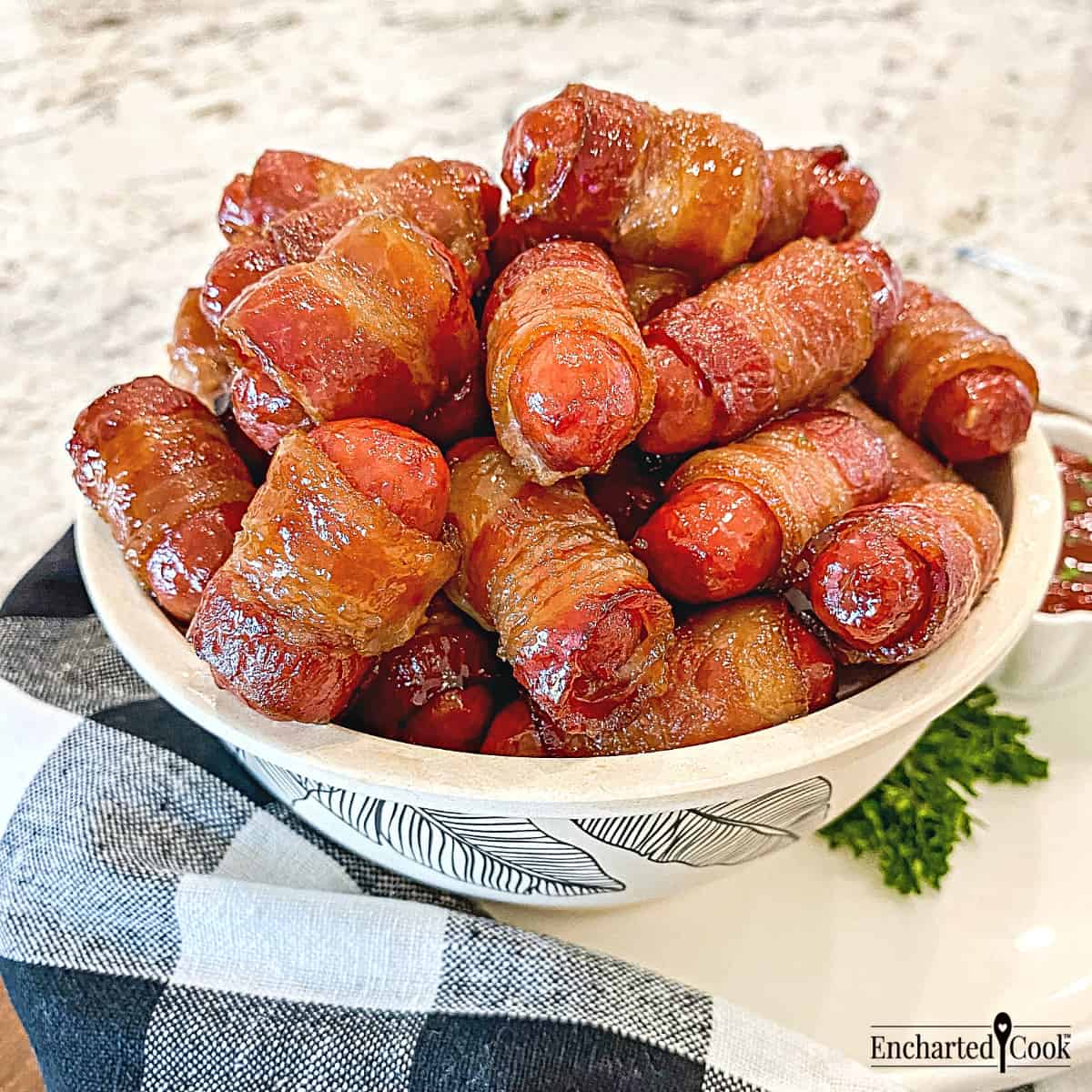 Bacon Wrapped Little Smokies in a bowl with a black and white napkin.
