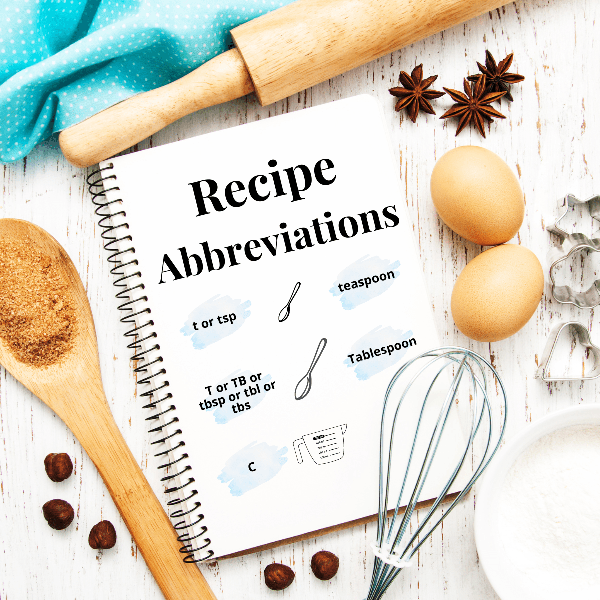 Rolling pin, whisk, and eggs surrounding a notebook with text reading "recipe abbreviations".