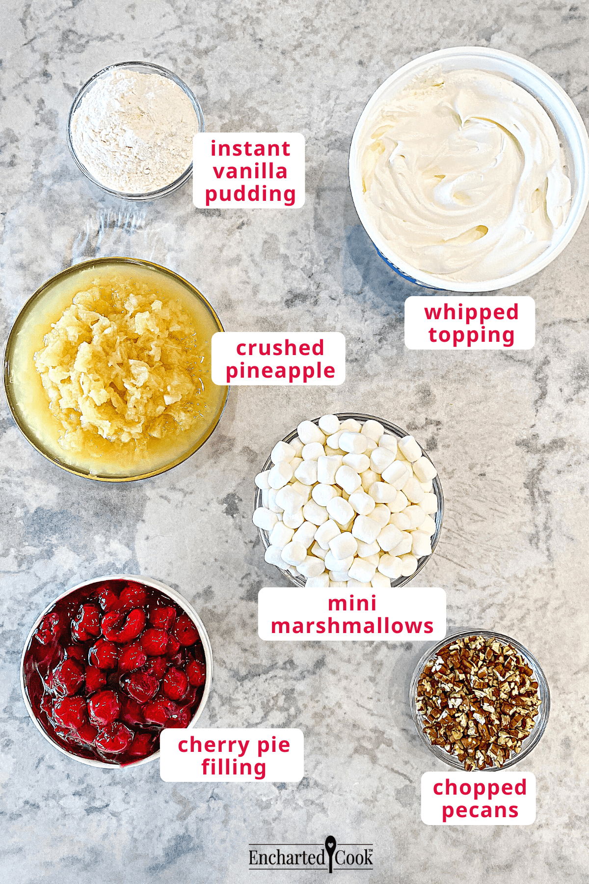 The ingredients, clockwise from top right: whipped topping, mini marshmallows, chopped pecans, cherry pie filling, crushed pineapple, and instant vanilla pudding.