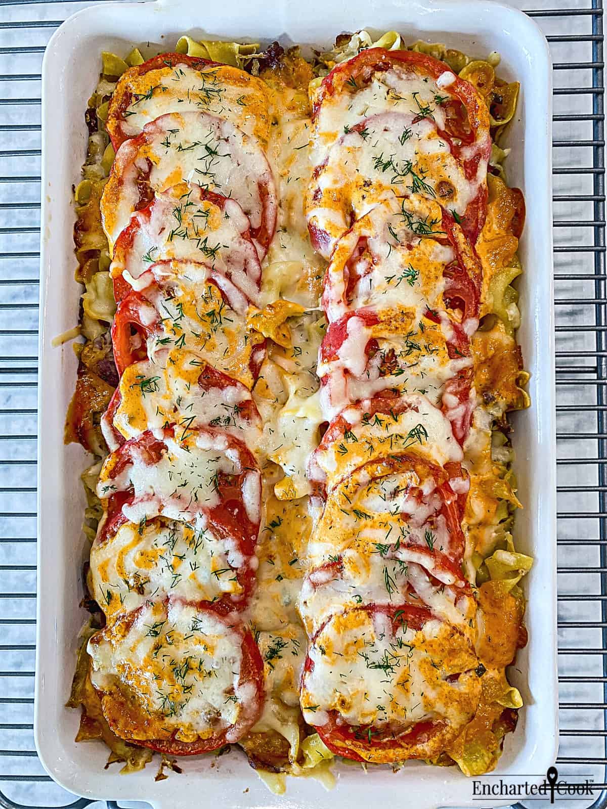 Reuben casserole topped with tomato, cheese, and thousand island dressing fresh from the oven.