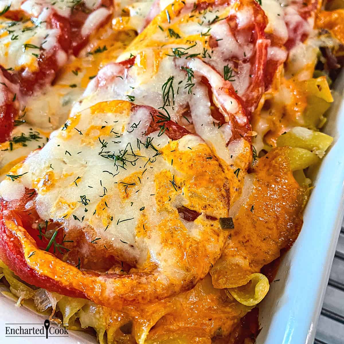 Close view of reuben casserole topped with tomato, cheese, and thousand island dressing fresh from the oven.