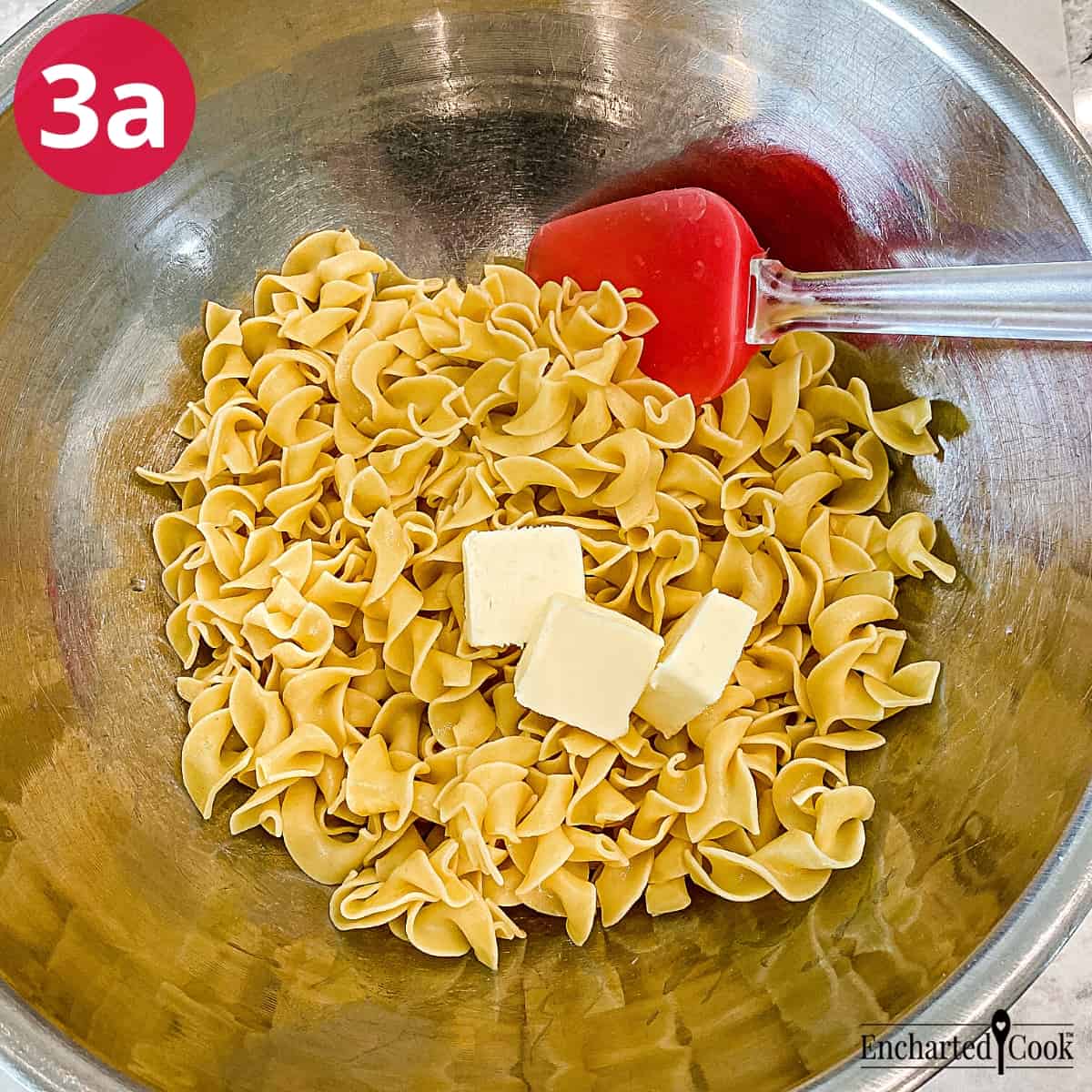 Process Photo 3a - Adding butter to hot noodles in a large mixing bowl.