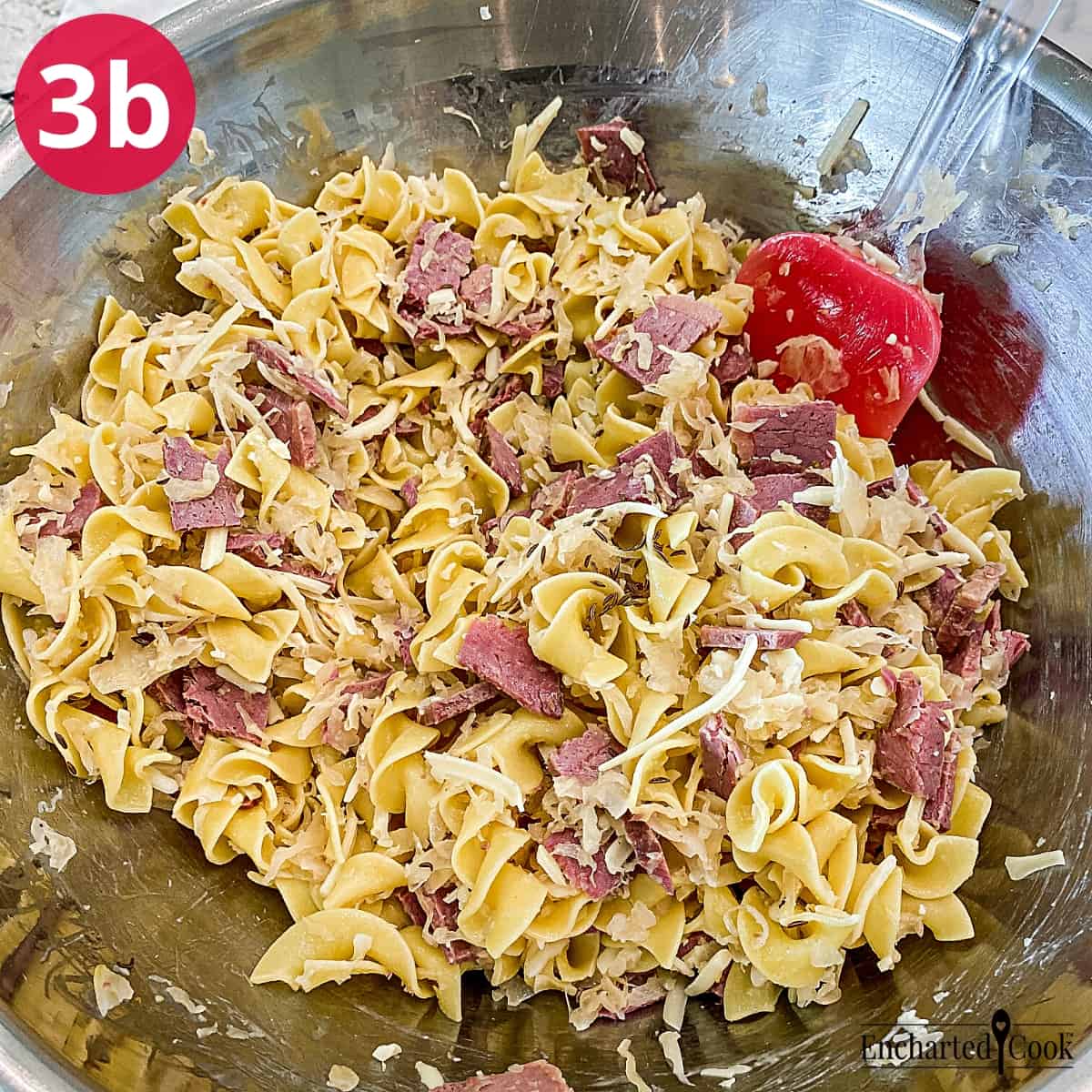 Process Photo 3b - Mixing corned beef, sauerkraut, shredded swiss cheese, and caraway seeds into the hot buttered noodles.