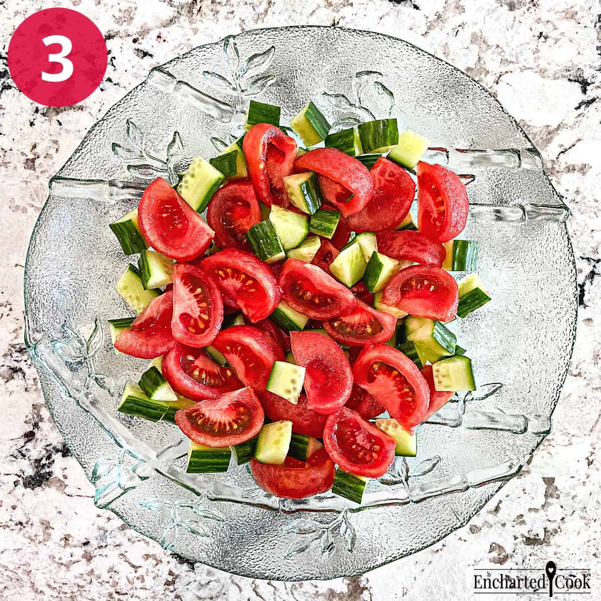 Process Photo 3 - Mixing wedges of tomatoes and sliced cucumber in a large green glass bowl.