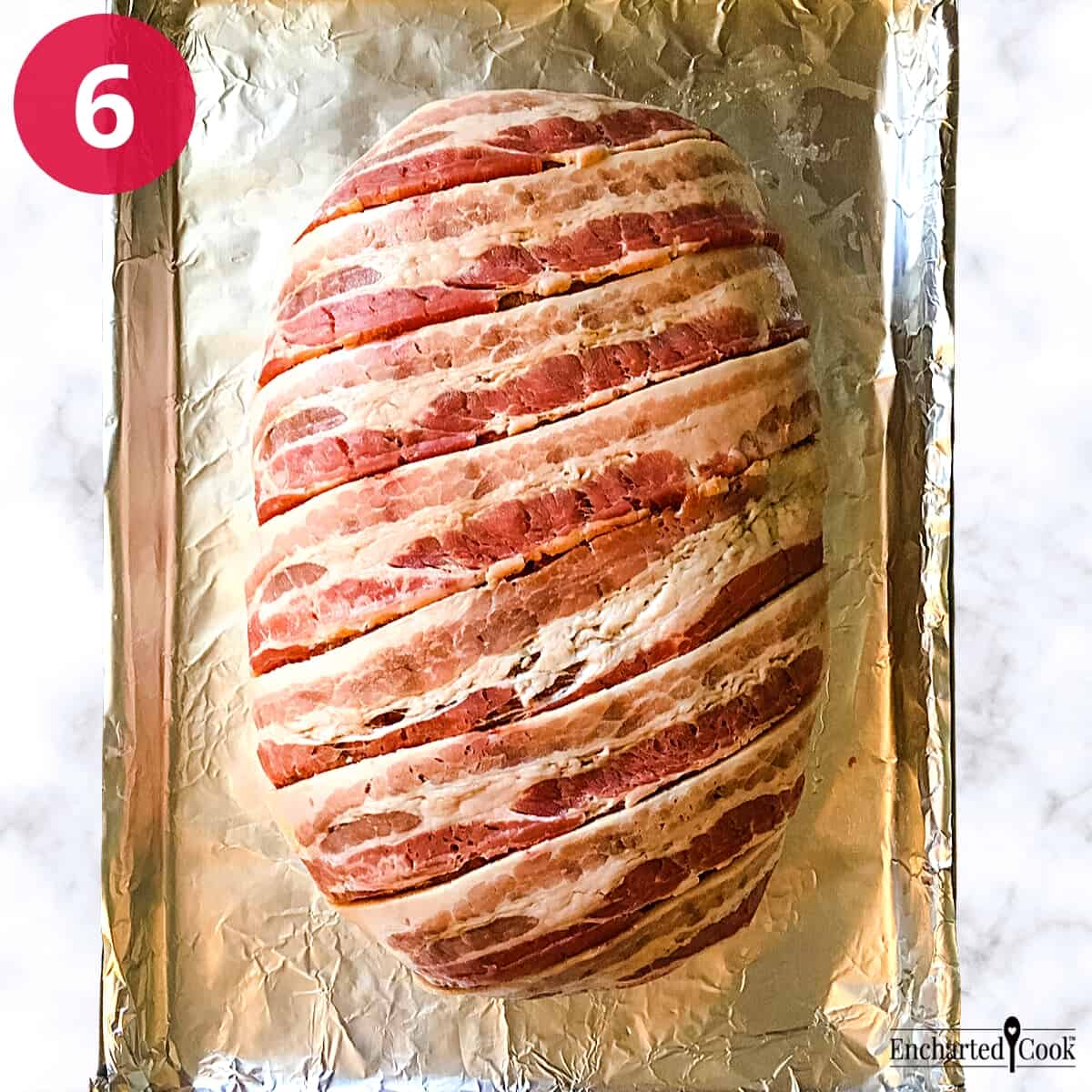 Process Photo 6 - The meatloaf mixture has been shaped into an oval log and covered in strips of bacon.