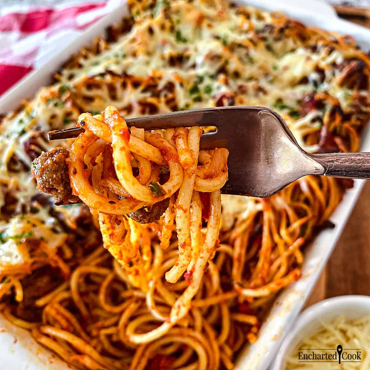 A forkful of baked spaghetti with meaty marinara sauce.