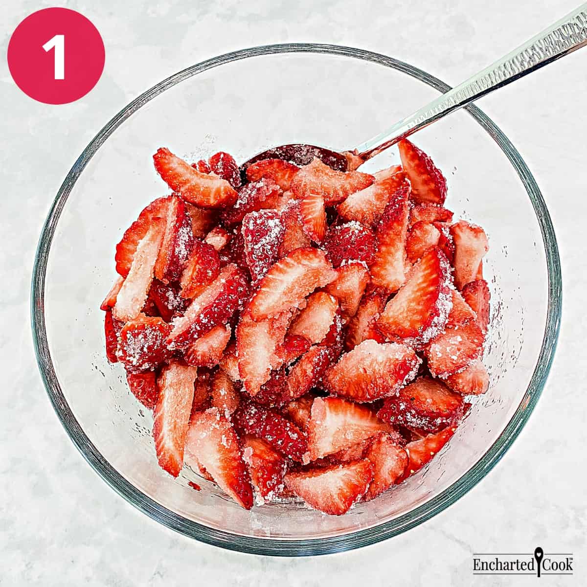 Process Photo 1 - Sugar has been added to sliced strawberries in a mixing bowl.
