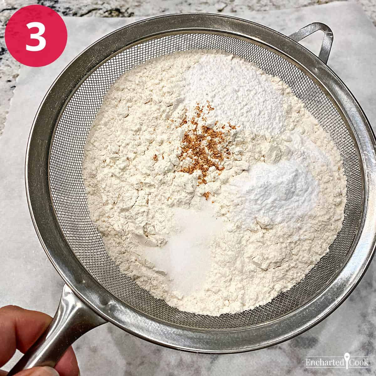 Process Photo 3 - Dry ingredients, like flour, leavening, salt, and spices are sifted together in a metal hand sieve.