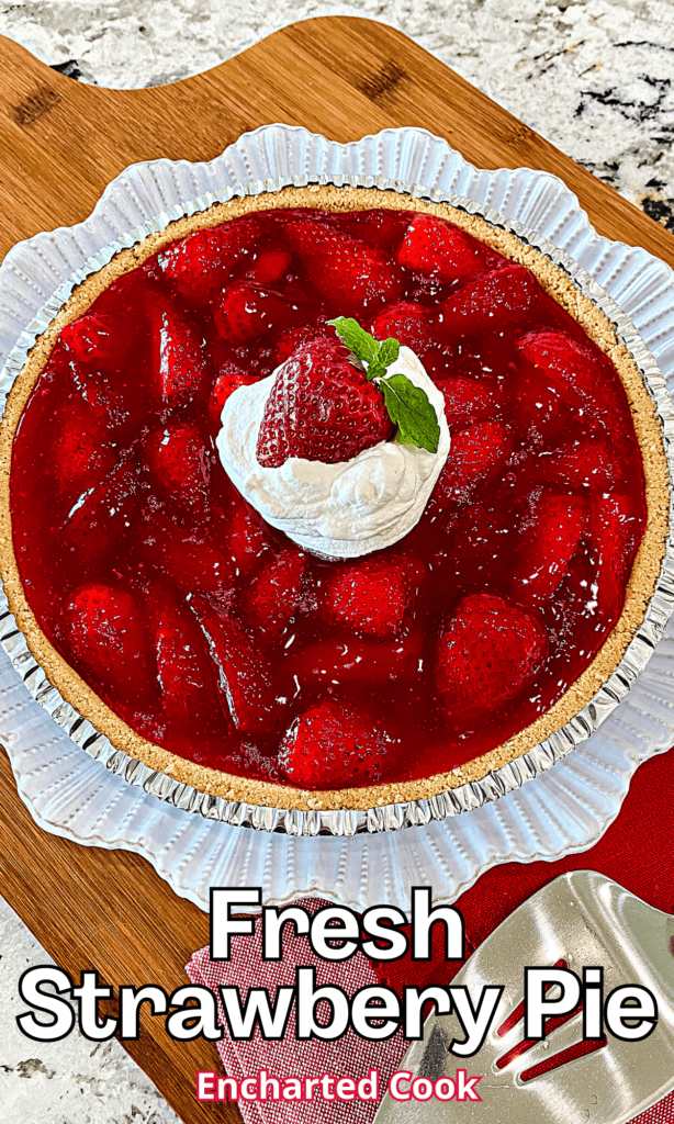 A whole strawberry pie topped with whipped cream on a white plate with text overlay.