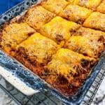 Lasagna with lots of melted cheese is cut into square servings and ready to serve.