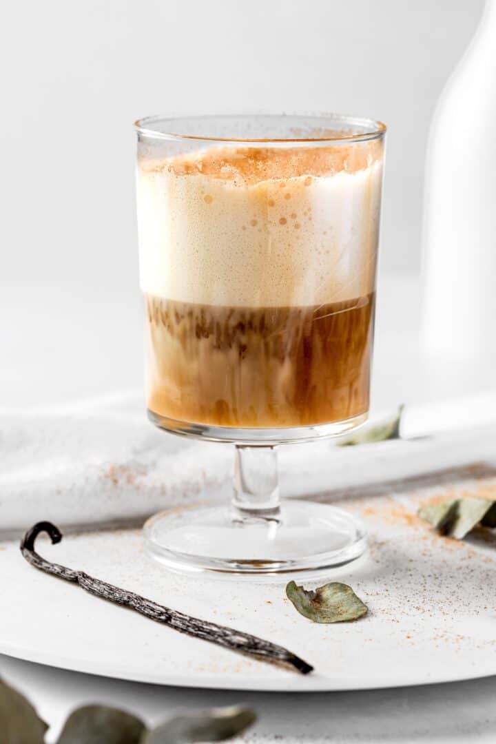 A coffee with a thick creamy head in a tall stemmed glass.