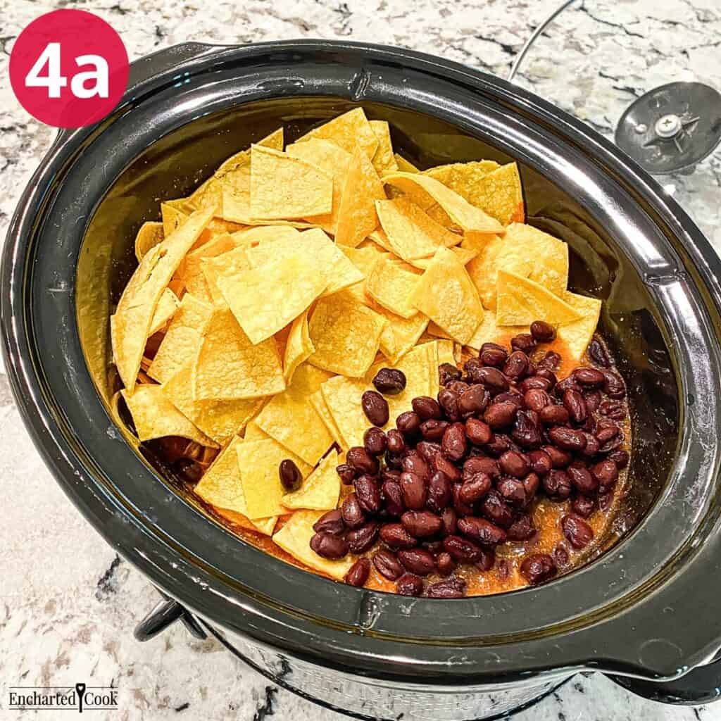 Process Photo 4a - Shredded cheddar cheese, cut corn tortillas, and black beans are added to the crock pot.