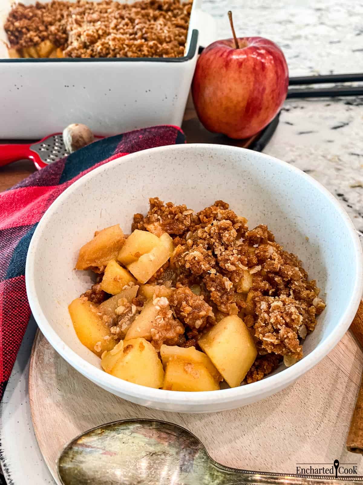 A bowl of cooked sliced apples with a crisp streusel topping.