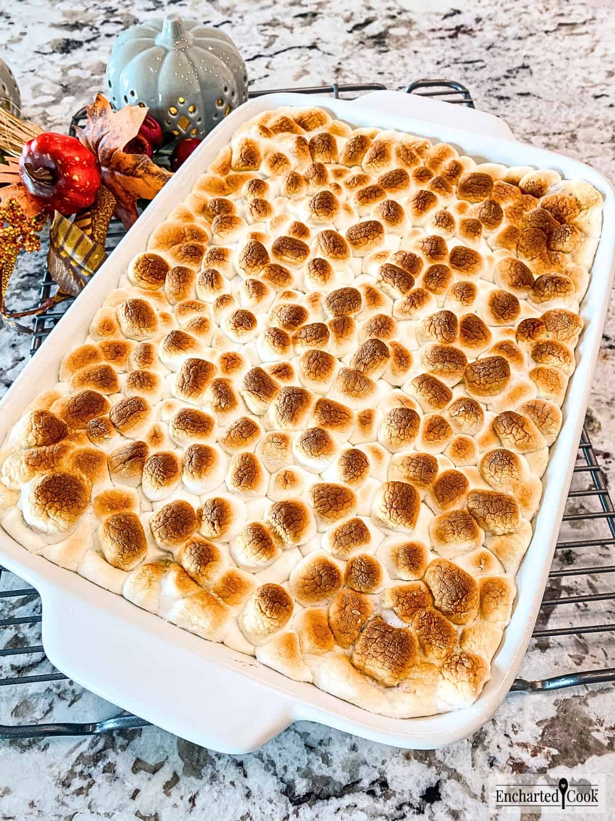 A fully baked sweet potato casserole topped with a layer of melted and toasted miniature marshmallows is ready to be served.