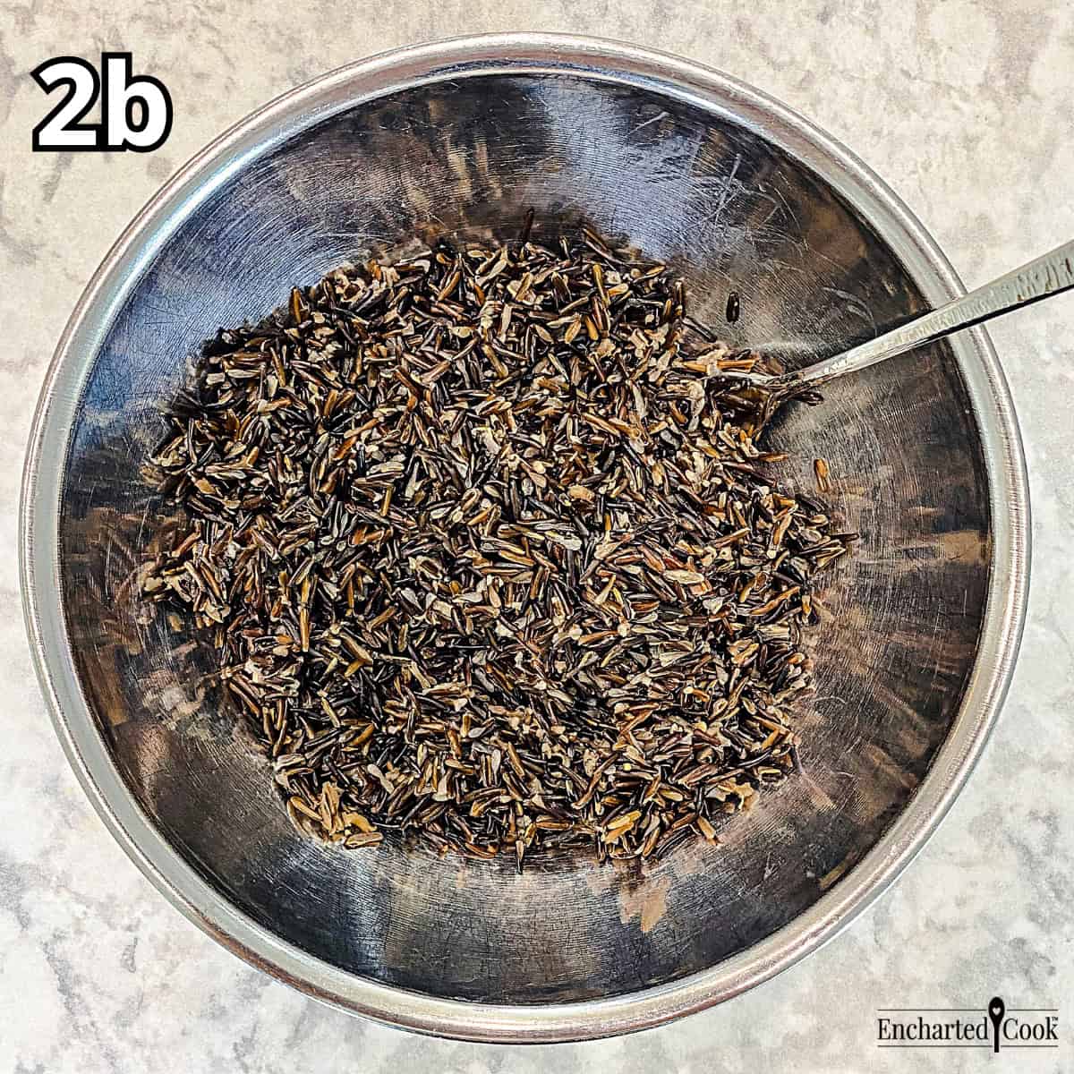Process Photo 2b - Cooling and fluffing the wild rice with a fork in a large bowl.