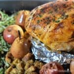 Golden roasted turkey breast surrounded with baked apples and pears, dressing, and green beans.