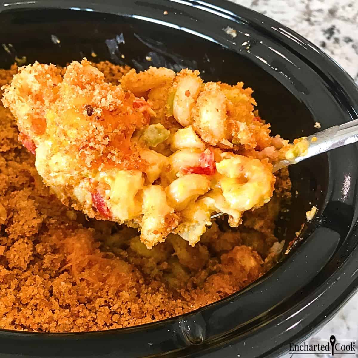Green Chile Macaroni and Cheese being spooned from a slow cooker.