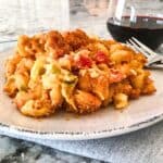 Green Chile Mac & Cheese on a plate with a glass of red wine.