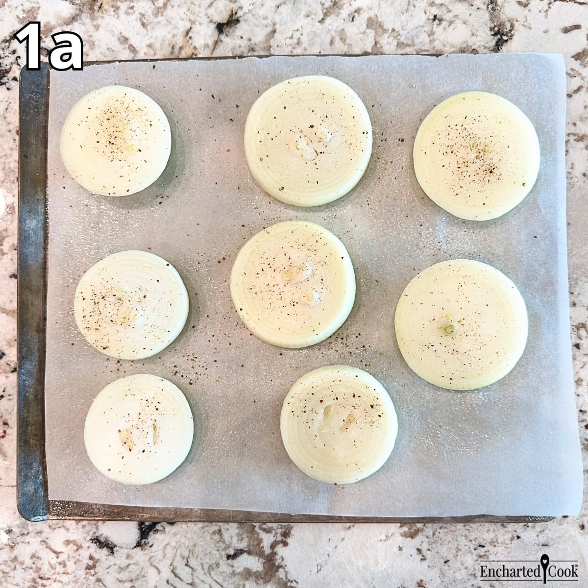 Process Photo 1a - Sliced onions on a parchment-lined baking sheet seasoned with salt and pepper.