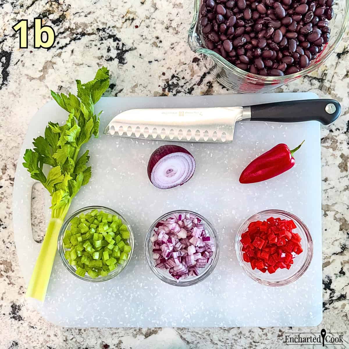 Process Photo 1b - Finely diced celery, red onion, and red pepper in small dishes on a white cutting board with black beans in a large measuring cup.