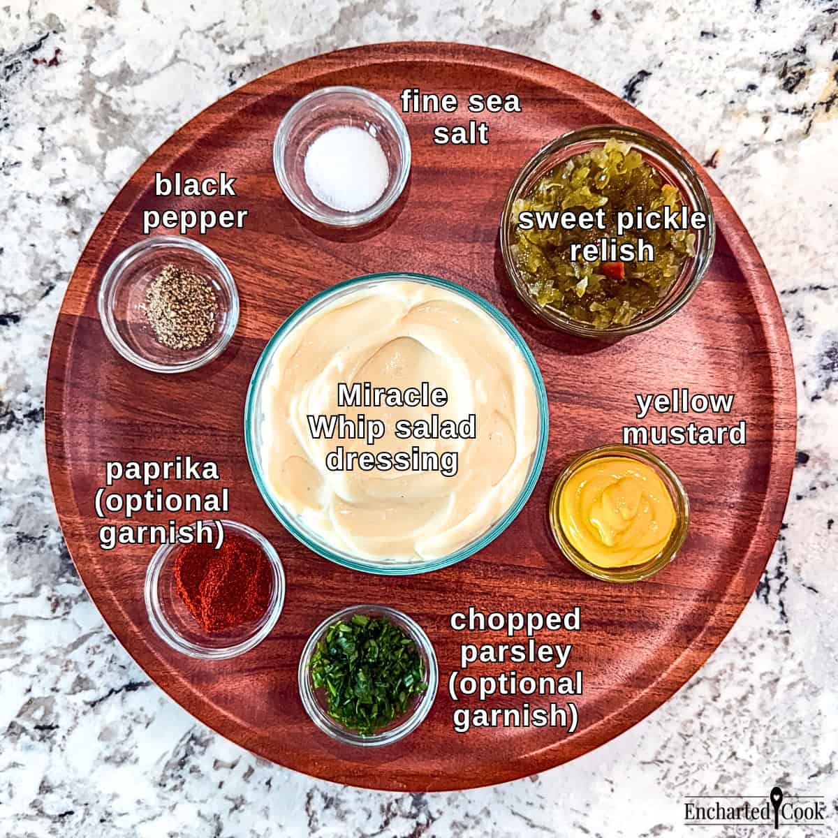 The ingredients for the dressing are on a wooden tray, clockwise from top right: sweet pickle relish, yellow mustard, chopped parsley, paprika, black pepper, fine sea salt, and Miracle Whip salad dressing in the center.