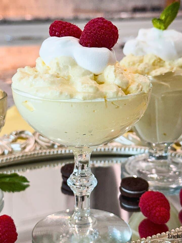 Lemon Cream Fluff in dessert glasses garnished with fresh raspberries and mint.